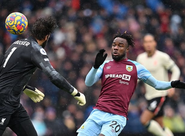 <p>Liverpool's Brazilian goalkeeper Alisson Becker (L) headers the ball clear from the path of Burnley's Ivorian defender Maxwel Cornet </p>