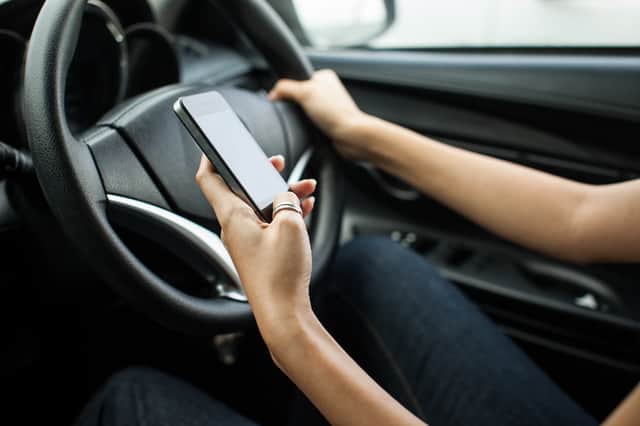 The new law will ban any use of handheld devices while driving