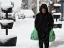 A pedestrian carries their shopping through the snow in Auchterarder, central Scotland, on February 18, 2022, as Storm Eunice brings high winds across the country.