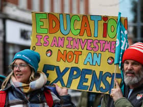 Teachers and members of the National Education Union (NEU) hold placards during a demonstration called by the NEU trade unions in the streets of Reading, on February 1, 2023 during a national strike day.  (Photo by Adrian DENNIS / AFP) (Photo by ADRIAN DENNIS/AFP via Getty Images)
