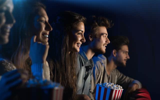 An audience of cinema goers enjoying popcorn - can you guess which of them is called Elizabeth? (Credit: Adobe) 