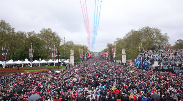 Crowds made their way down the Mall and towards Buckingham Palace, to greet to the new King and Queen at the balcony of Buckingham Palace. Shortly after the royal arrival on the balcony, a traditional Red Arrow flyover - which had been scaled back due to weather - brightened the rainy skies over London. (Credit: Getty Images)