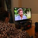 A family gather around the television in Liverpool to watch Prince Harry and his wife Meghan's explosive tell-all interview with Oprah Winfrey in March (Photo: PAUL ELLIS/AFP via Getty Images)