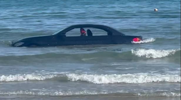 A convertable BMW was washed out to see after parking on a beach in Cornwall