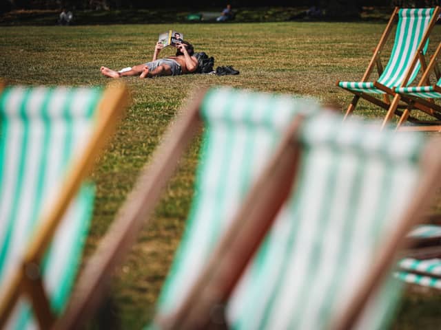 A man reads a book while sunbathing in Green Park in central London on September 5, 2023 as the country experiences a late heatwave. 