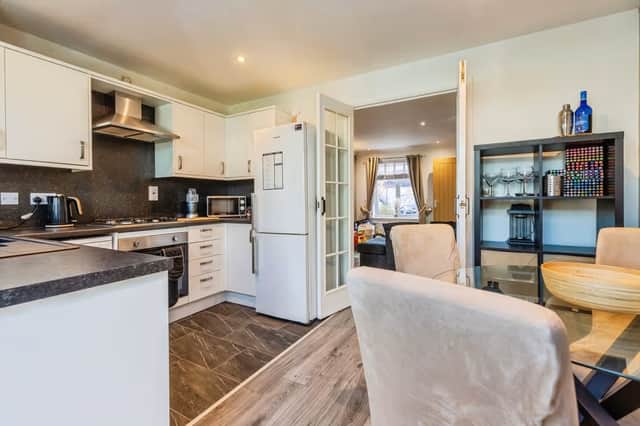 The kitchen connects directly with the lounge and opens towards the bright sun room at the rear