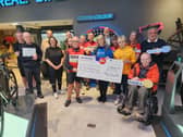 Sue Swire, of Rosemere Cancer Foundation (front, second left) receives Rotary’s 2026 Ribble Valley Ride donation from (front, left to right) Peter Spencer, of Clitheroe Rotary, Jacquie Baldwin, of Accrington Rotary, and Bill Honeywell, of Clitheroe Rotary, watched by (back row, left to right) David Stacey, of Ribble Cycles, Craig Holt, of Heidelberg Materials, John Spencer, of Clitheroe Rotary and Malcolm Baldwin, of Accrington Rotary plus others from the local cycling fraternity