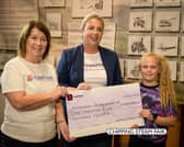 Chipping Steam Fair representative  Devon Billings (right) presents the committee’s donation to the charity’s volunteer games stall holders Michelle Davies (left) and Louise Grant