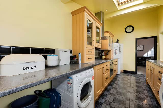 The large kitchen offers practical space for everyday cooking, complementing the two separate reception rooms on the ground floor