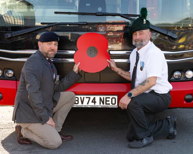Transdev colleagues who are former Armed Forces personnel with a poppy in front of a bus, operated by Transdev, for the Poppy Appeal 2026 campaign renewal