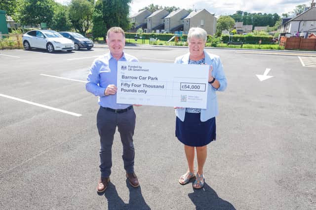 Councillor Street with Barrow parish councillor Karen Heyworth with a cheque for the car park improvement works; part of a wider scheme to improve Barrow village hall.