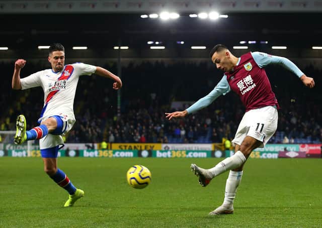 BURNLEY, ENGLAND - NOVEMBER 30:  Dwight McNeil of Burnley crosses the ball ahead of Martin Kelly of Crystal Palace during the Premier League match between Burnley FC and Crystal Palace at Turf Moor on November 30, 2019 in Burnley, United Kingdom. (Photo by Alex Livesey/Getty Images)
