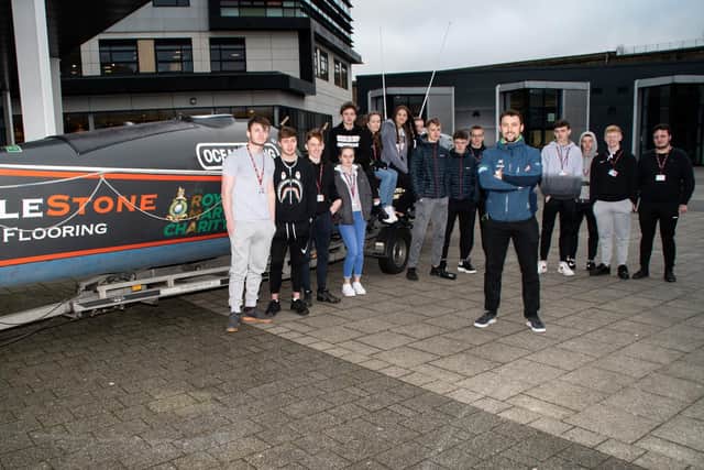 Matt is pictured students at Burnley College next to the boat he will be using with his team mates for the epic rowing challenge.