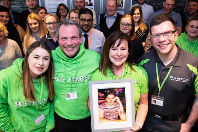 Fiona and Dave proudly hold a photograph of their much loved son Ben, surrounded by supporters and ambassadors at the BK's Heroes charity information day