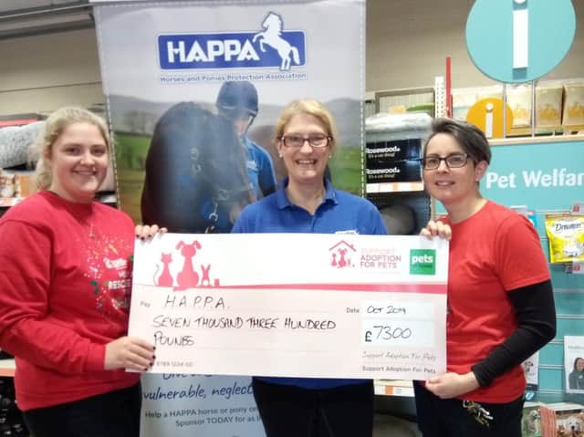 Maria Hurley from HAPPA (centre) with two Pets at Home members of staff