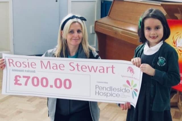 Pendleside Hospice fundraiser Jo Applegate made a surprise visit to Rosie Mae Stewart's school to present her with a certificate and accept a cheque for the money the six-year-old raised by having her hair cut