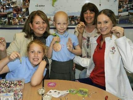 Tia (centre) with (from left to right) her sister Tegan, headteacher Mrs Kathleen McKeating, Olympian Sophie Hitchon and Wendy Hitchon as they make an angel during Sophie's visit to the school in 2016.