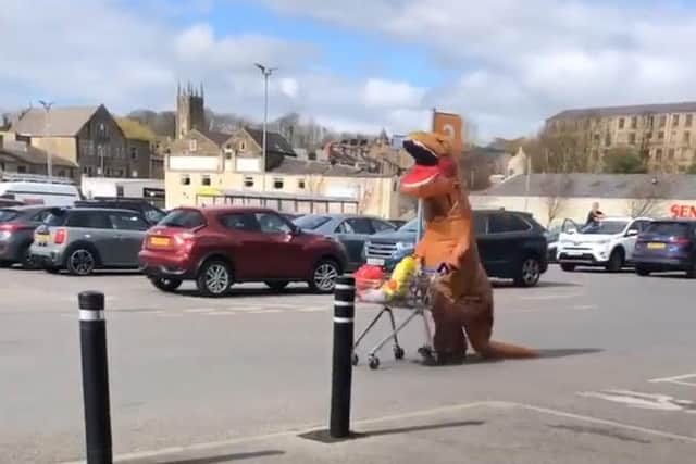 Happy as a lark doing his shopping is the friendly T Rex caught on camera in Padiham by Rick Cunliffe