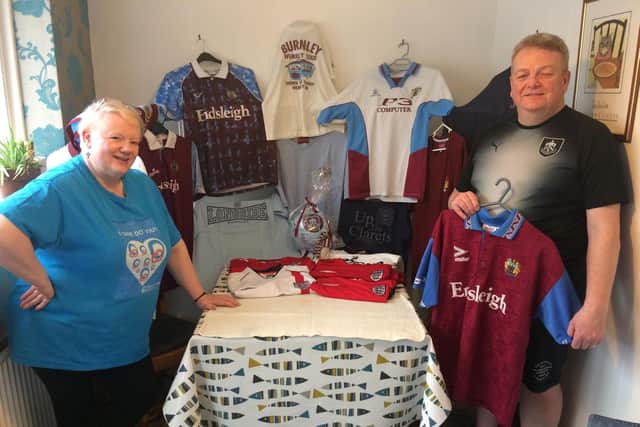 Chris and Diane Flynn with the collection of Burnley and England shirts they are raffling off for a party for carers across the area.