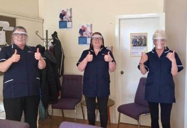 Staff at Complete Care Services give their visors the thumbs up