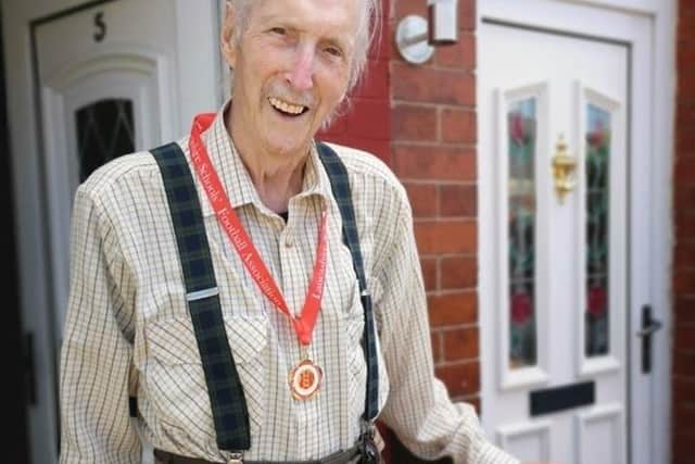 John proudly shows off his medal that will become a family heirloom