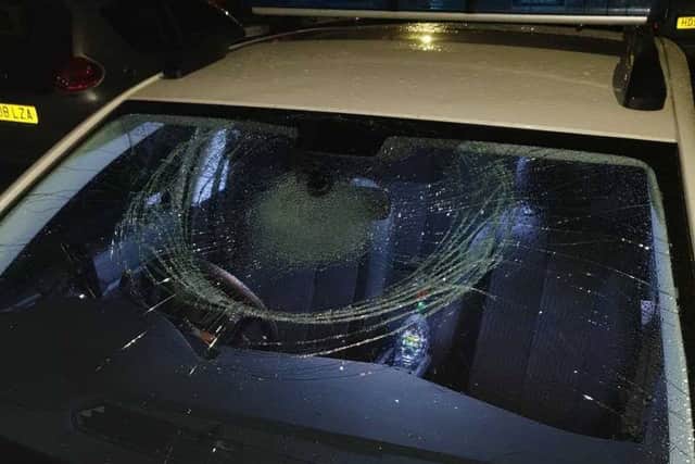 The marked police car had its windows smashed and tyres slashed