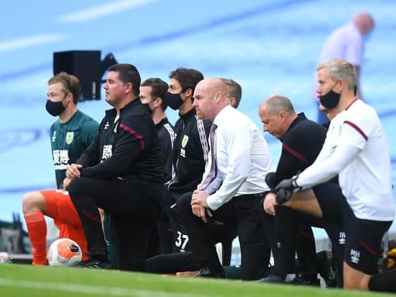 Sean Dyche and his staff take a knee at kick-off