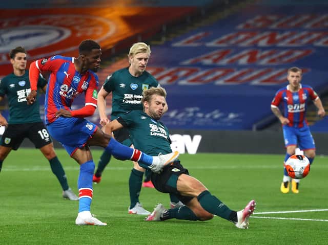 Wilfried Zaha of Crystal Palace shoots as Charlie Taylor of Burnley attempts to block during the Premier League match between Crystal Palace and Burnley FC at Selhurst Park on June 29, 2020 in London, United Kingdom. (Photo by Hannah McKay/Pool via Getty Images)