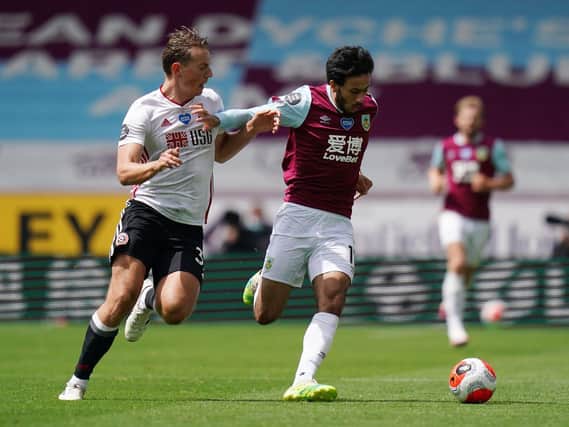 Dwight McNeil of Burnley is challenged by Sander Berge of Sheffield United during the Premier League match between Burnley FC and Sheffield United at Turf Moor on July 05, 2020 in Burnley, England. (Photo by Jon Super/Pool via Getty Images)