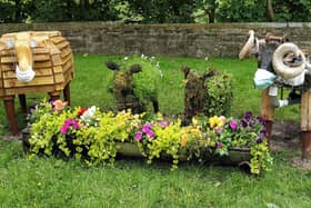 The recycled sheep, feeding from a flower-filled container