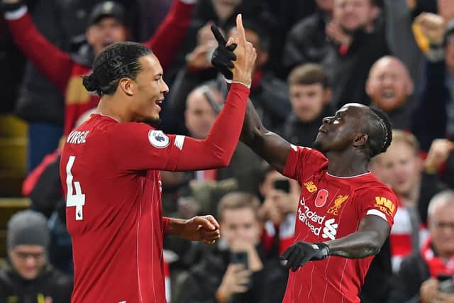 Liverpool's Senegalese striker Sadio Mane (R) celebrates with Liverpool's Dutch defender Virgil van Dijk (L) after scoring their third goal during the English Premier League football match between Liverpool and Manchester City at Anfield in Liverpool, north west England on November 10, 2019. (Photo by Paul ELLIS / AFP)