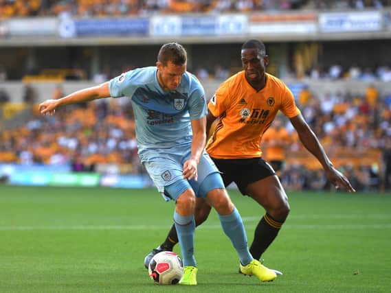 Chris Wood of Burnley is tackled by Willy Boly of Wolverhampton Wanderers during the Premier League match between Wolverhampton Wanderers and Burnley FC at Molineux on August 25, 2019 in Wolverhampton, United Kingdom. (Photo by Harry Trump/Getty Images)