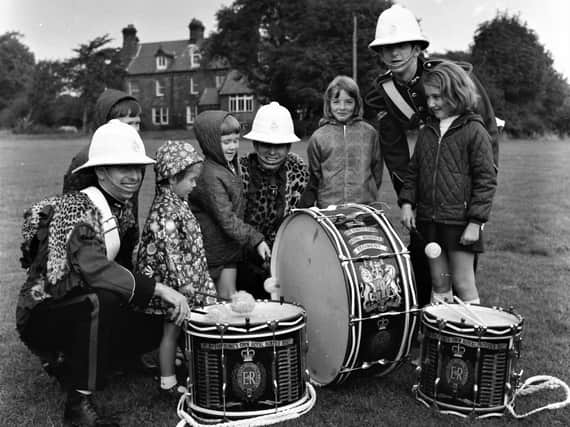 Drummers Staple, Smith and Lewis, of the Corps of Drums, the King's Own Border
Regiment, let these children from Highfield Avenue, Burnley, try their hand with the drumsticks