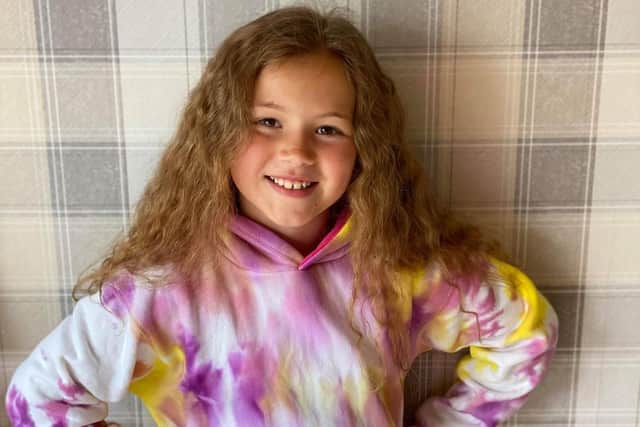 Nyla models one of her unique tie-dye hoodies she is making to help the charity her dad works for