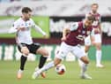 Jay Rodriguez of Burnley is challenged by Ollie Norwood of Sheffield United during the Premier League match between Burnley FC and Sheffield United at Turf Moor on July 05, 2020 in Burnley, England. (Photo by Peter Powell/Pool via Getty Images)