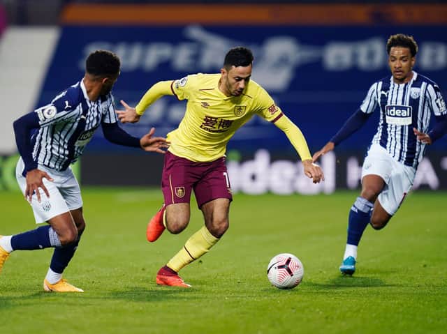 Dwight McNeil of Burnley runs with the ball under pressure from Darnell Furlong and Matheus Pereira of West Bromwich Albion during the Premier League match between West Bromwich Albion and Burnley at The Hawthorns on October 19, 2020 in West Bromwich, England.