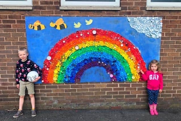 Noah and his sister Ava with the recycled bottle top Rainbow collage students at St Stephen's Primary School in Burnley created during lockdown