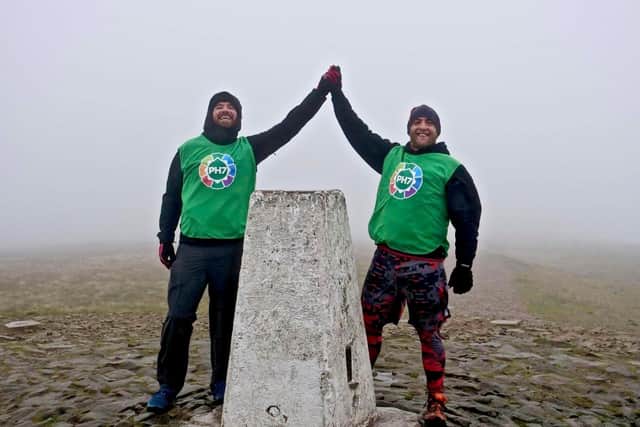 Pictured at the end of their challenge to climb Pendle hill as many times as possible in 24 hours are Scott Pickles (right) and John Deehan. Photo: David Belshaw