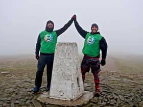 Pictured at the end of their challenge to climb Pendle hill as many times as possible in 24 hours are Scott Pickles (right) and John Deehan. Photo: David Belshaw