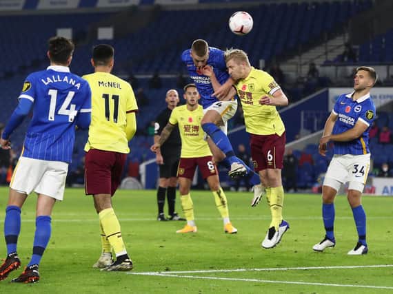 Burnley's Ben Mee and Adam Webster of Brighton and Hove Albion challenge for the ball during the Premier League match between Brighton & Hove Albion and Burnley at American Express Community Stadium on November 06, 2020 in Brighton, England.