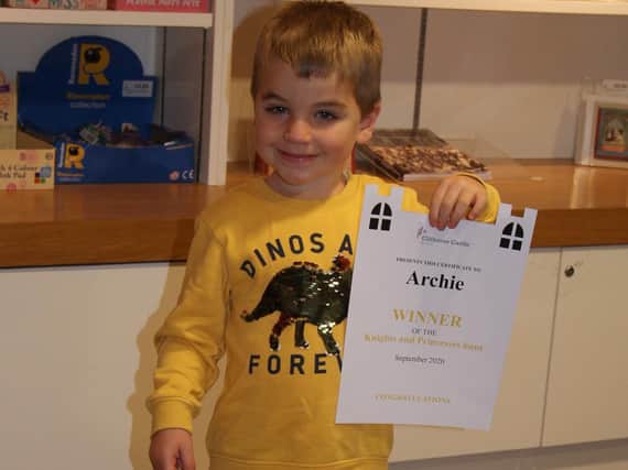Little Archie with his prize and certificate