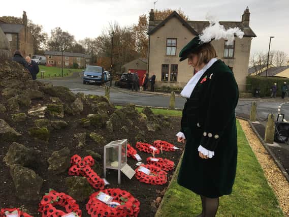 Lancashire's High Sheriff Catherine Penny surveys the Remembrance tributes laid at the memorial cross at Hurst Green