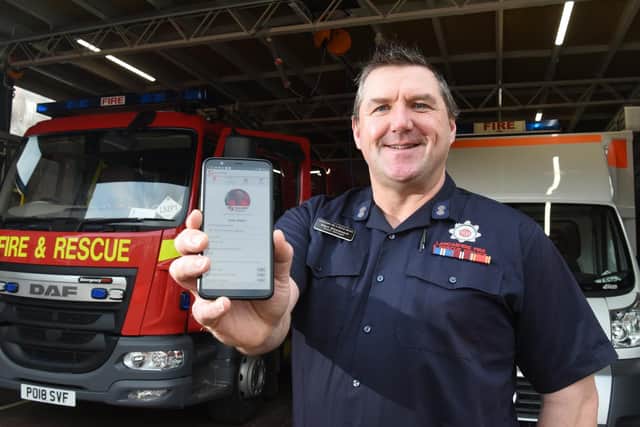 Mark shows how he is alerted to  NHS Responder tasks via an app on his telephone   Photo: Neil Cross