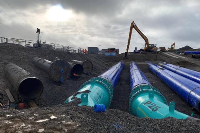 Some of the new blue pipes which were connected into the Haweswater Aqueduct this month. The old pipes can be seen behind him to the left