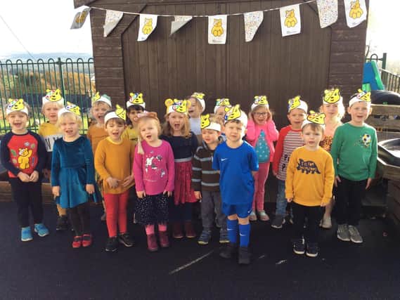 Pictured are nursery and Reception class children showing off the Pudsey Bear hats they made