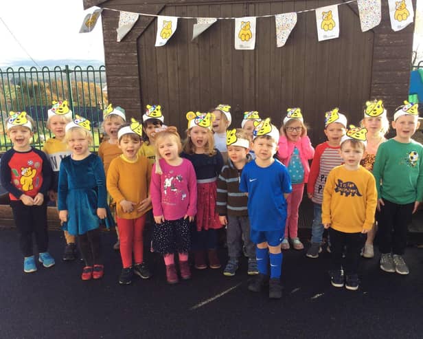 Pictured are nursery and Reception class children showing off the Pudsey Bear hats they made
