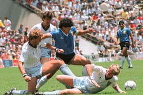 Argentinian midfielder Diego Maradona (C) dribbles past three English defenders 22 June 1986 in Mexico City during the World Cup quarterfinal soccer match between Argentina and England. Maradona scored two goals, the first one with his left hand as he jumped for the ball in front of goalkeeper Peter Shilton, as Argentina beat England 2-1.