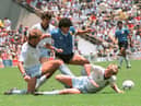 Argentinian midfielder Diego Maradona (C) dribbles past three English defenders 22 June 1986 in Mexico City during the World Cup quarterfinal soccer match between Argentina and England. Maradona scored two goals, the first one with his left hand as he jumped for the ball in front of goalkeeper Peter Shilton, as Argentina beat England 2-1.