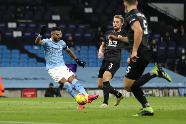 Riyad Mahrez of Manchester City scores his team's first goal during the Premier League match between Manchester City and Burnley at Etihad Stadium on November 28, 2020 in Manchester, England.