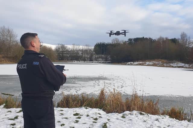 A police officer with  a drone at Barrow Brook pond where youths were spotted on the ice